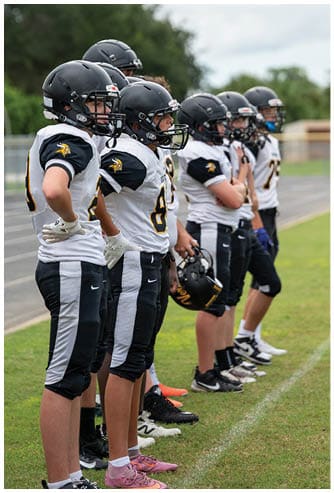 A person wearing a black football helmet and a white Bishop Verot football uniform with the number 17 is holding a football and appears focused on the game. Descripci n generada con IA