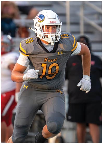 A person wearing a yellow football uniform with the number 20 and the word Verot stands on a football field. Descripci n generada con IA