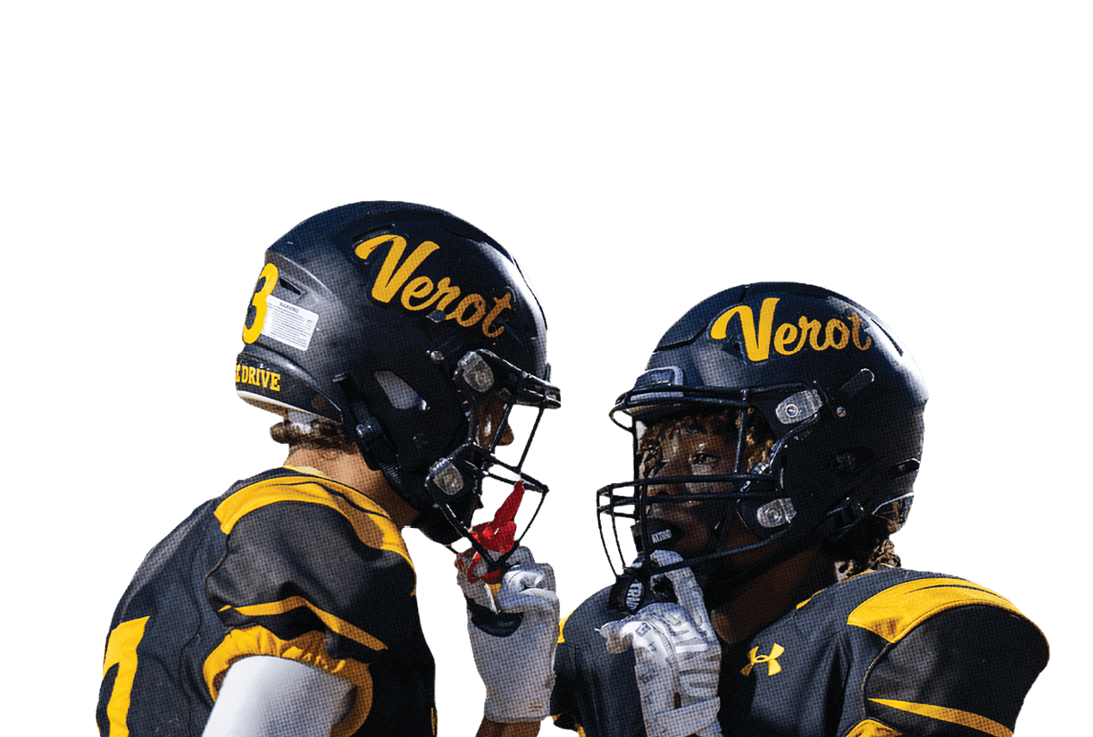 Two people in black and yellow football uniforms and helmets are facing each other, appearing to communicate during a game. Descripci n generada con IA