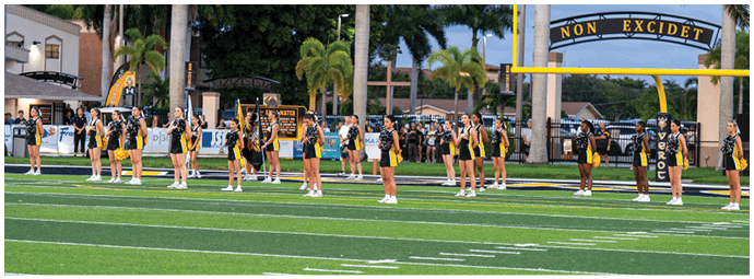 People standing on a green sports field with white yard lines and wearing athletic shoes and shorts. Descripci n generada con IA