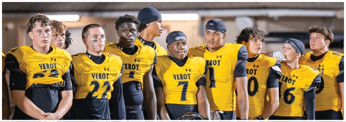 A group of people wearing yellow sports jerseys with the word “VEROT" stand closely together in a line, appearing focused and attentive. Descripci n generada con IA