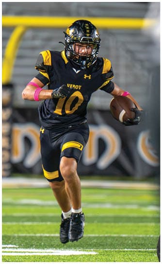 A person wearing a black and yellow football uniform with the number 10 is running on a field while holding a football. Descripci n generada con IA