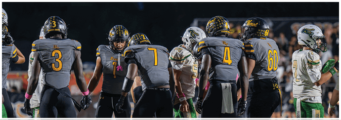 A group of people wearing football helmets and uniforms are gathered on a field during a game at night. Descripci n generada con IA