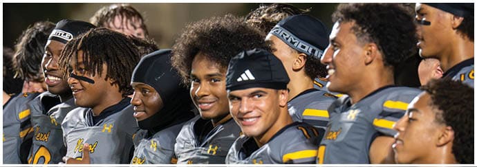 A group of people wearing matching sports uniforms stand closely together smiling and looking in the same direction. Descripci n generada con IA