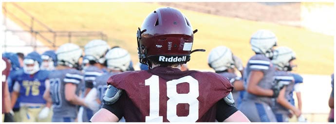 A football player wearing a blue and white uniform. Description generated by AI