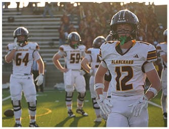 A group of football players on a field. Description generated by AI