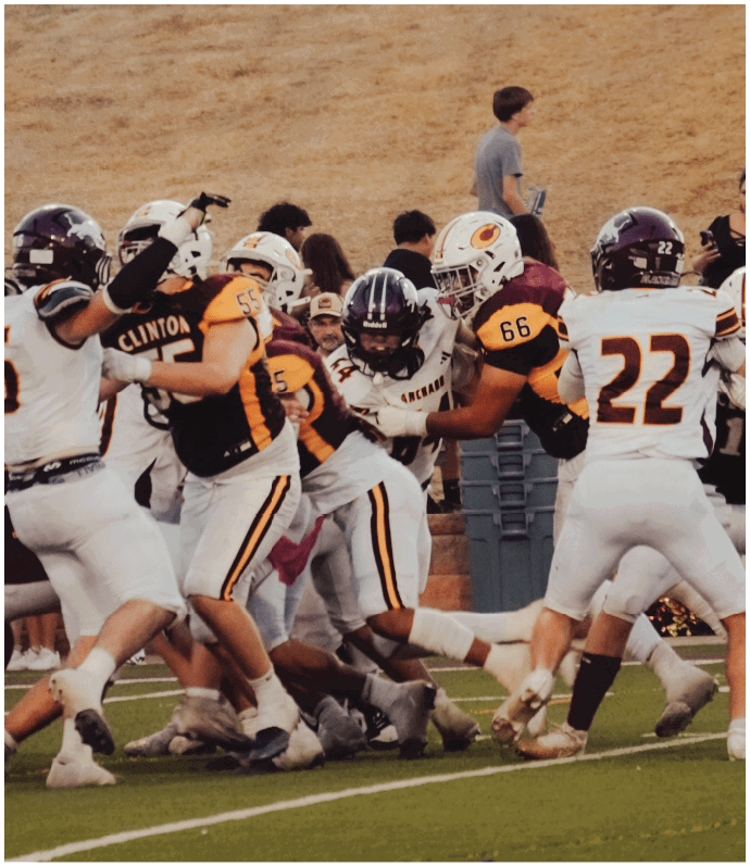 Three football players in blue and white uniforms running on a field. Description generated by AI