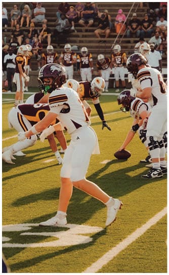 A football player catching a ball. Description generated by AI
