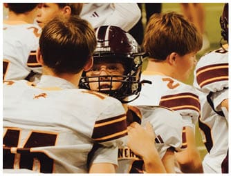 A group of football players on a field. Description generated by AI