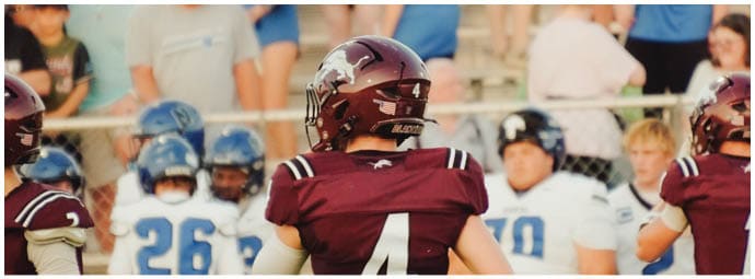 A football player wearing a blue and white uniform. Description generated by AI