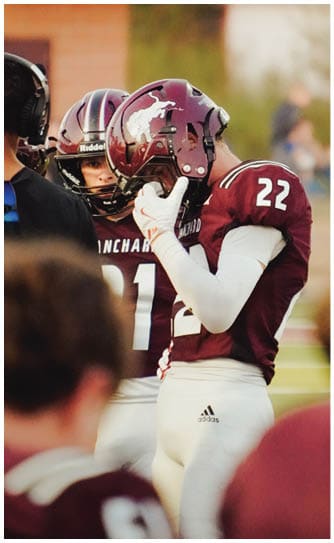 A football player catching a ball. Description generated by AI