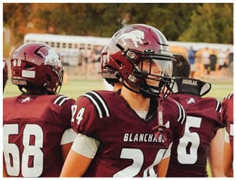 A group of football players on a field. Description generated by AI