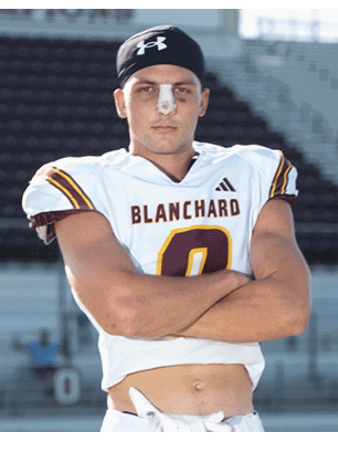 A young man wearing a white and black jersey with the number 14 on it. Description generated by AI