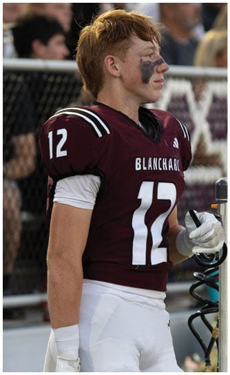 A football player catching a ball. Description generated by AI