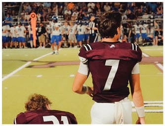A group of football players on a field. Description generated by AI
