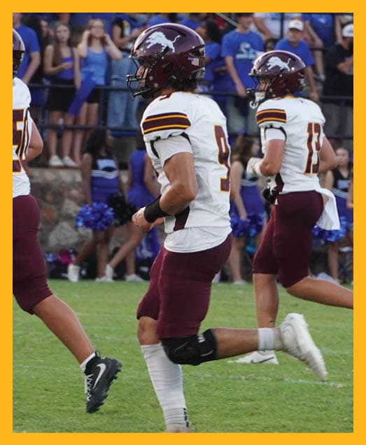 A football player in a white uniform is running with a football in his hand. AI generated content