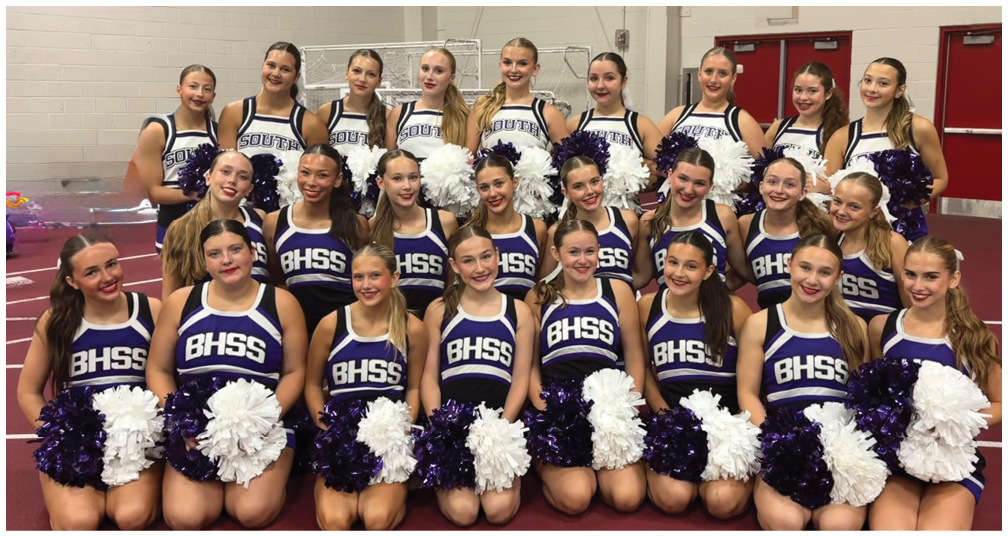 A group of people dressed in matching cheerleading uniforms with BHSS on the front are posing together holding purple and white pom-poms. Description generated by AI