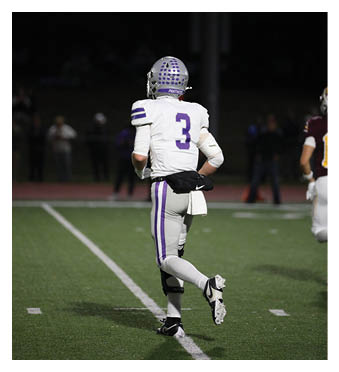 A football player wearing a blue and red jersey. Description generated by AI