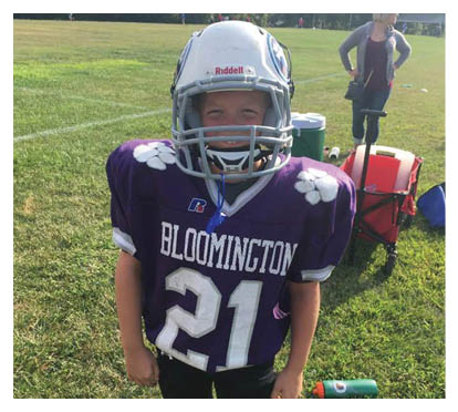 A football player wearing a blue and red jersey. Description generated by AI