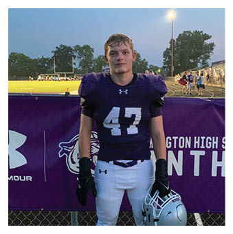 A football player wearing a blue and red jersey. Description generated by AI