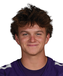 A person with tousled hair is standing and smiling while wearing a purple football jersey with the number 17 and the word Bloomington on it. Description generated by AI