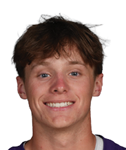 A person with short hair is smiling and wearing a purple sports jersey with the number 24 and the word Bloomington on the front. Description generated by AI