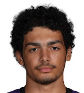 A person with curly hair wearing a purple Bloomington sports jersey with the number 42 stands with hands behind their back against a white background. Description generated by AI