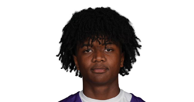 A person with curly hair is wearing a purple Bloomington sports jersey with the number 3 and standing against a white background. Description generated by AI