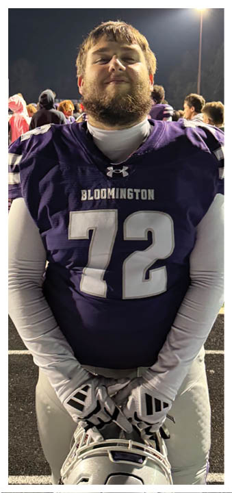 A football player wearing a blue and red jersey. Description generated by AI