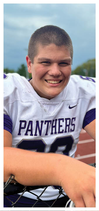 A football player wearing a blue and red jersey. Description generated by AI
