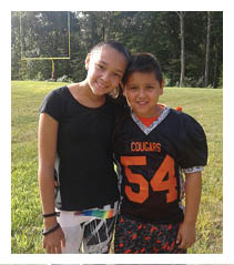 Two football players wearing black jerseys with the word Vista on them. Description generated by AI