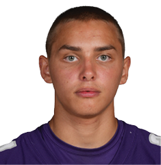 A person wearing a purple Bloomington sports jersey with the number 34 stands facing forward against a white background. Description generated by AI