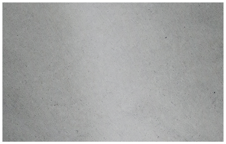 A close-up view of a textured gray fabric surface with small scattered dark specks. Description generated by AI