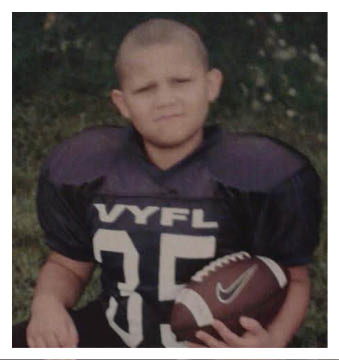 A football player wearing a blue and red jersey. Description generated by AI