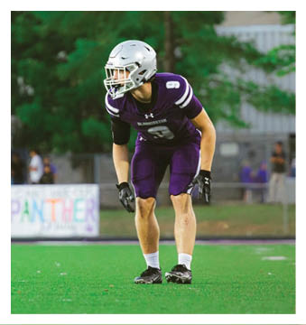 A football player wearing a blue and red jersey. Description generated by AI
