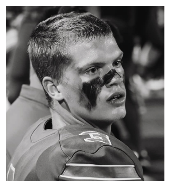 A football player wearing a blue and red jersey. Description generated by AI
