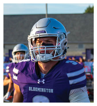 A football player wearing a blue and red jersey. Description generated by AI