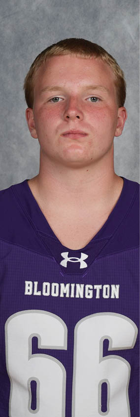 Person wearing a purple Bloomington sports jersey with the number 66 stands against a gray textured background. Description generated by AI