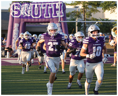 Athletes in purple and white football uniforms run onto a field through an inflatable archway labeled “South Panthers" during a game event. Description generated by AI