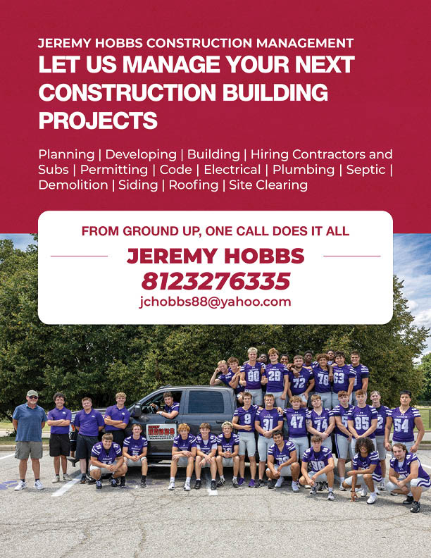 A group of people wearing matching sports jerseys pose together outdoors in front of a truck with a sign advertising construction management services and contact information. Description generated by AI