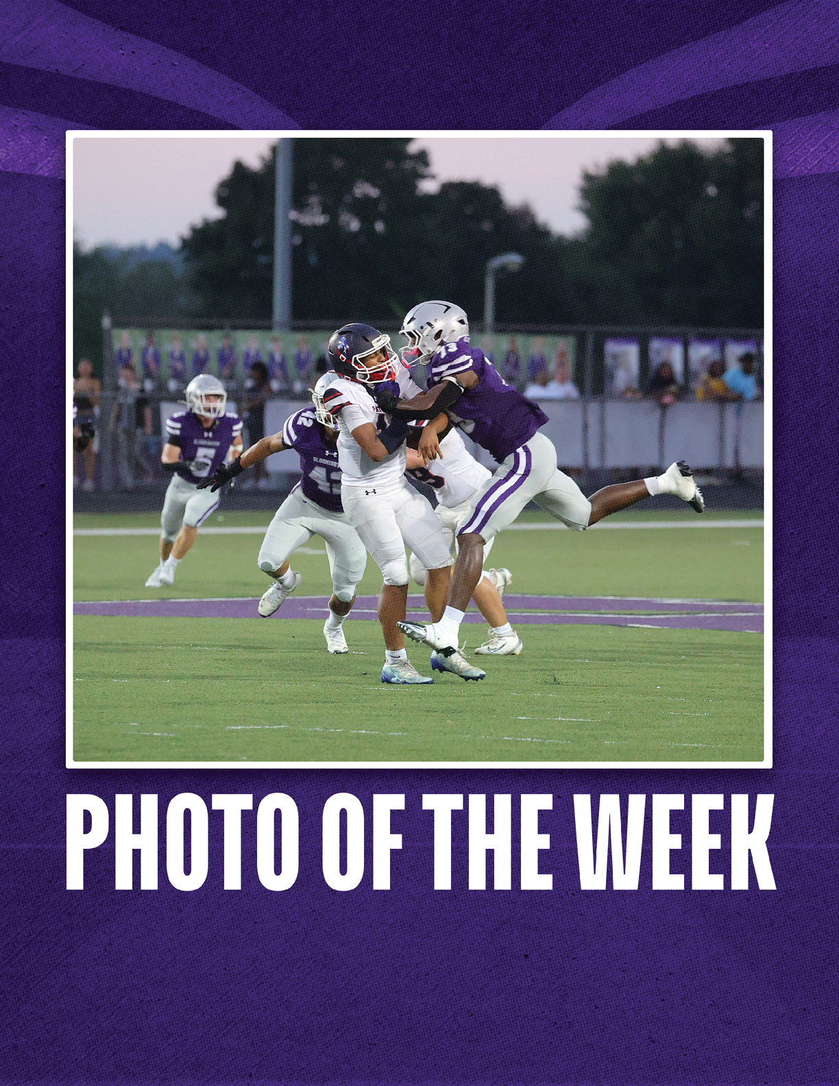 A group of people in football uniforms are actively engaged in a tackle on a football field during a game. Description generated by AI