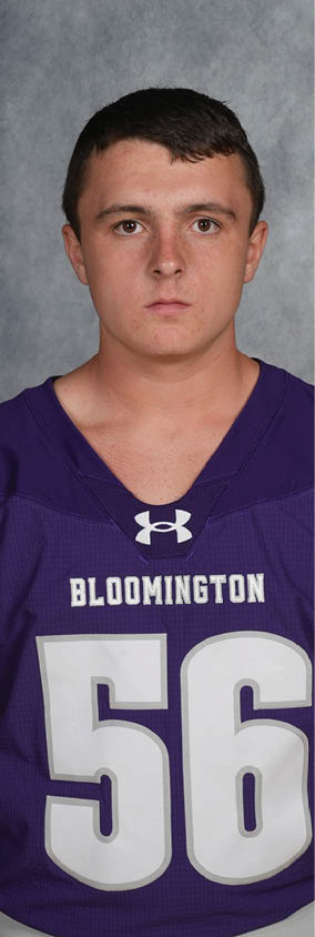 Person with short dark hair wearing a purple sports jersey with the word Bloomington and the number 56 on it. Description generated by AI