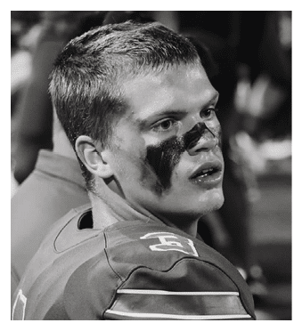 A football player wearing a blue and red jersey. Description generated by AI