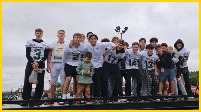 A group of people wearing white sports jerseys with the word Titans and numbers 14 and 13 are smiling and posing closely together. Description generated by AI