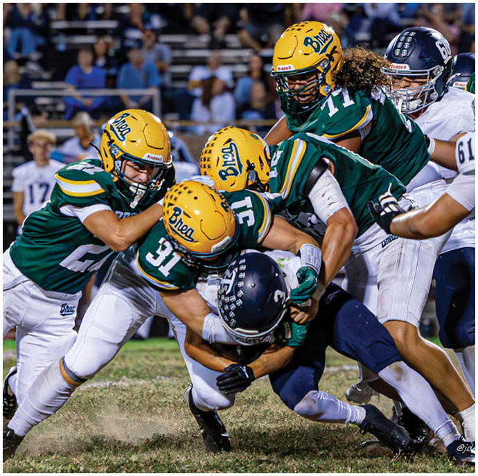 Three football players in blue and white uniforms running on a field. Description generated by AI