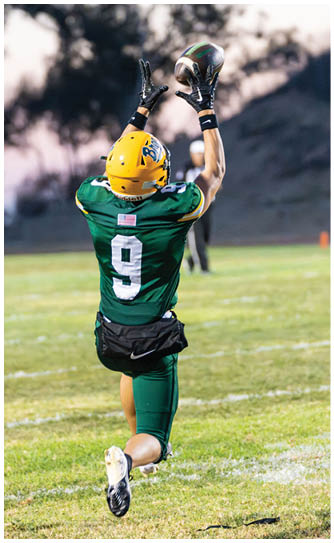 A football player catching a ball. Description generated by AI