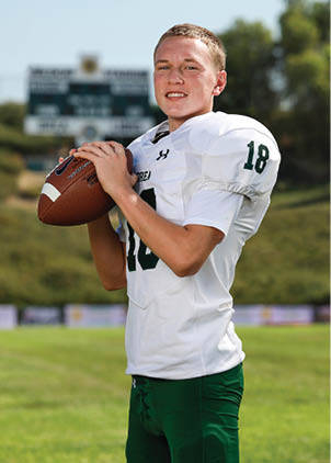 A young man wearing a white and black jersey with the number 14 on it. Description generated by AI