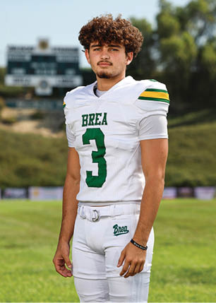 A young man wearing a white and black jersey with the number 14 on it. Description generated by AI