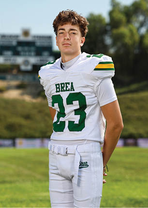 A young man wearing a white and black jersey with the number 14 on it. Description generated by AI