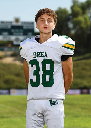 A young man wearing a white and black jersey with the number 14 on it. Description generated by AI